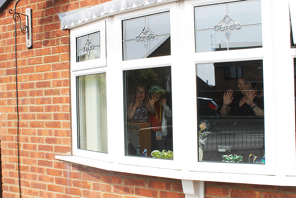 Childrenand mum waving through window